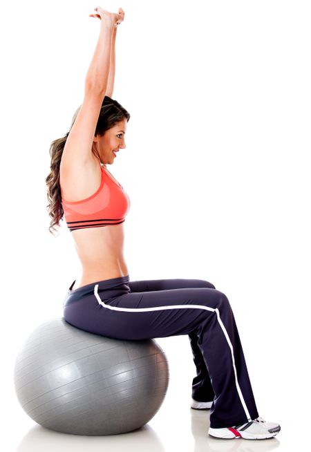 Woman exercising with a Swiss ball - isolated over a white background