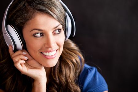 Happy woman portrait with headphones - isolated over a black background
