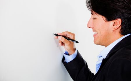 Business man holding a pen and writing - isolated over white