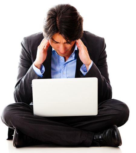 Worried business man working with a laptop computer - isolated over white