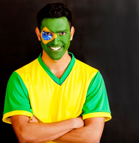 Confident Brazilian man with arms crossed and painted face