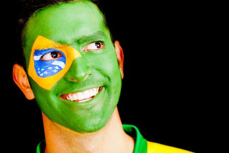 Happy man from Brazil with the Brazilian flag painted on his face