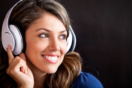 Woman portrait listening to music with headphones and smiling