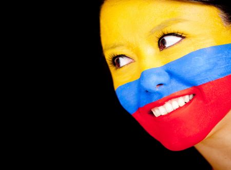 Woman with the flag Colombia painted on her face - isolated over a black background