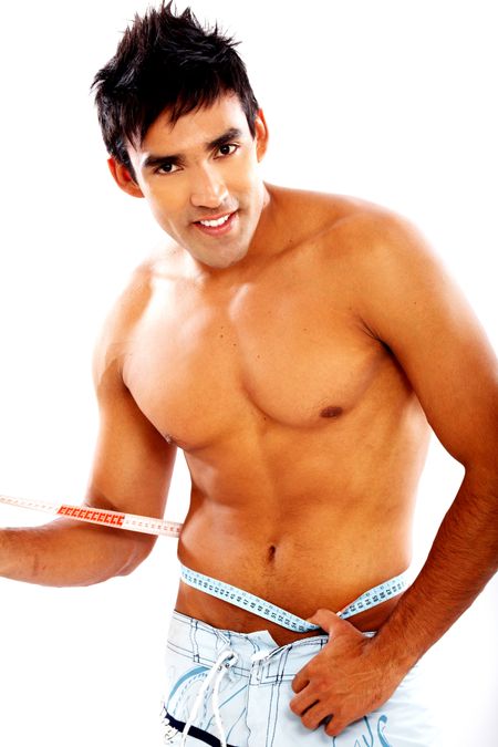 healthy man smiling and measuring his waist - isolated over a white background