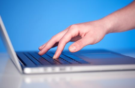 Close up of hand pressing keyboard buttons on desk