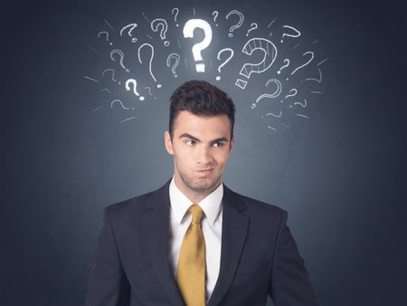 Young businessman with white question marks above his head