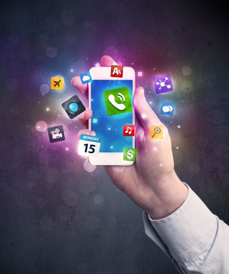 Caucasian hand in business suit holding a smartphone with colorful media icons