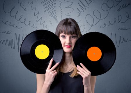 Young lady holding vinyl record on a grey background with scribbles around her
