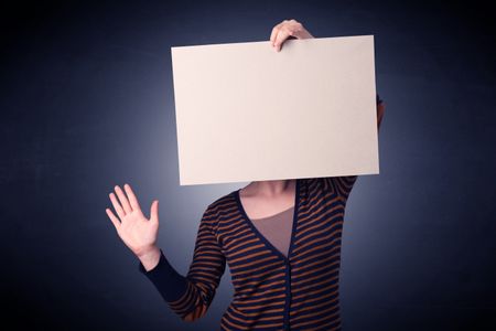 Young casual woman hiding behind a blank piece of paper