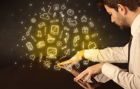 Male hands touching interactive table with yellow mixed media icons on it