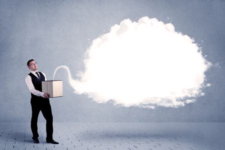 A young cheerful business person holding a cardboard box with illustration of white empty cloud concept.