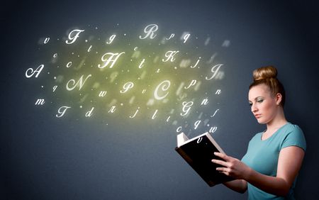 Casual young woman holding book with shiny letters flying out of it