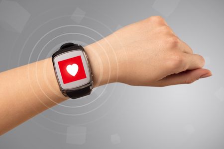 Naked female hand with smartwatch and with heart rate icon on the watch