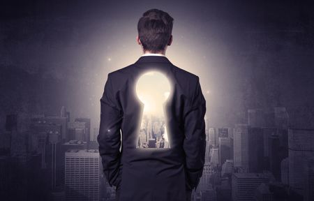 Young businessman standing and thinking with keyhole on his back and city graphic around