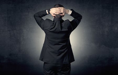 Young businessman standing and thinking alone