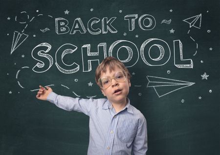 Adorable little boy with blackboard and back to school concept