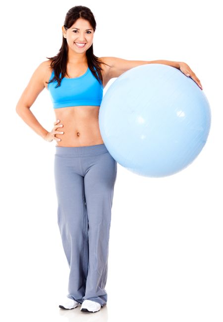 Fit woman with Swiss ball - isolated over a white background