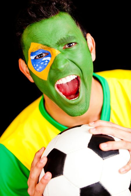 Excited Brazilian football fan scraming with flag painted on his face