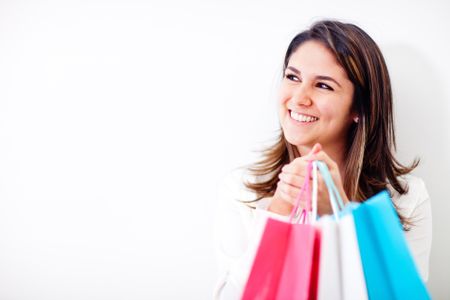 Happy shopping woman holding bags and smiling - isolated