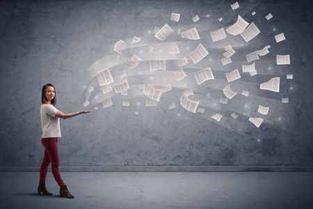 Caucasian businesswoman holding newspapers, which are floating away from his hands