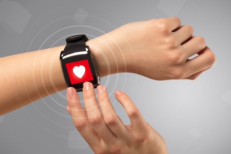 Naked female hand with smartwatch and with heart rate icon on the watch