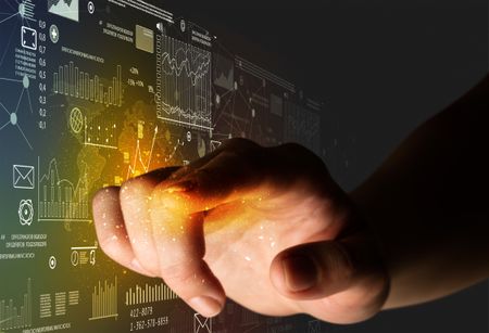 Female finger touching a beam of light surrounded by charts and graphs