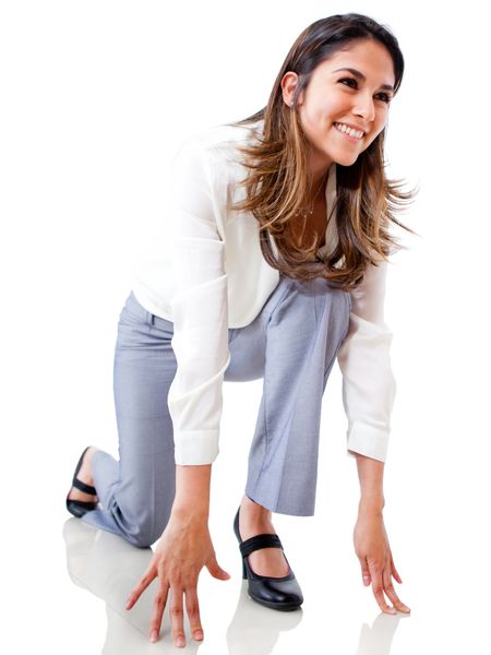 Businesswoman in position to run - isolated over a white background