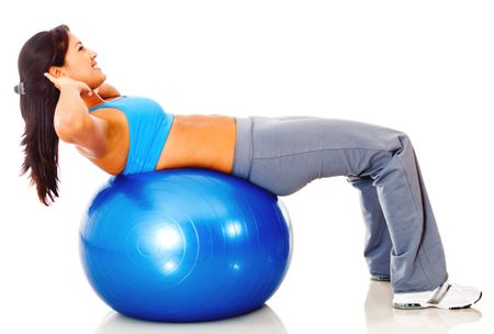 Athletic woman exercising with a Swiss ball - isolated over white