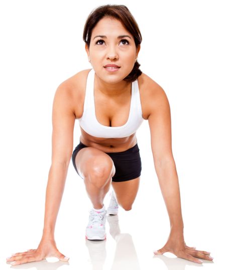 Sportive woman set to run - isolated over a white background