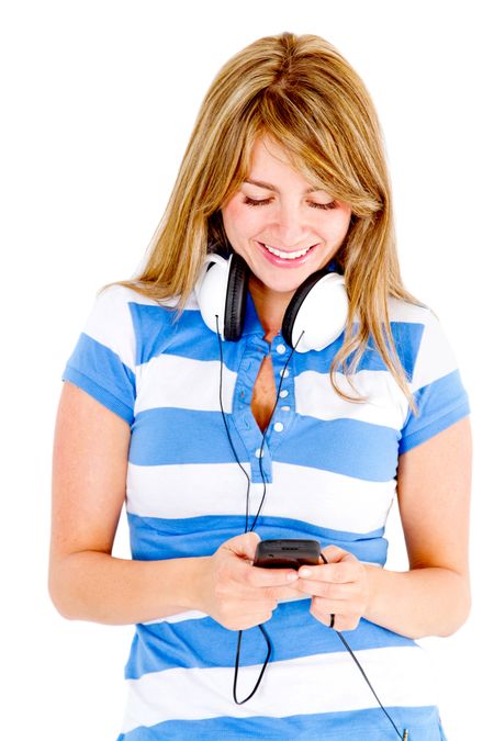 Young woman with headphones listening to music on cell phone - isolated