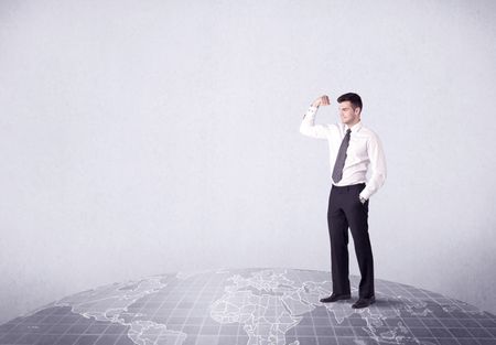 An elegant young male businessman standing on top of the world, pointing up concept with drawn earth map.