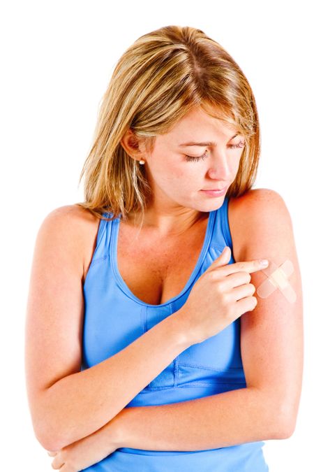 Woman putting a band-aid on her arm isolated over white