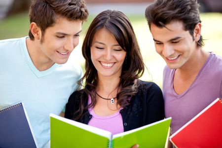 Group of students with notebooks smiling outdoors