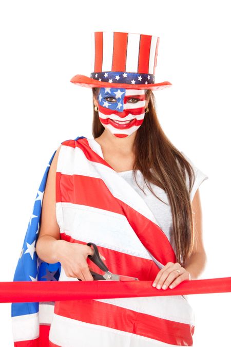 American woman with the USA flag painted on her face cutting a ribbon at an opening