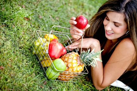 Healthy eating woman with a basket of fruits Ã?Â?Ã?Â� outdoors