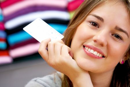 woman smiling and holding a credit card in a shop