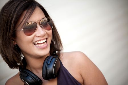 Beautiful woman portrait with sunglasses and headphones outdoors
