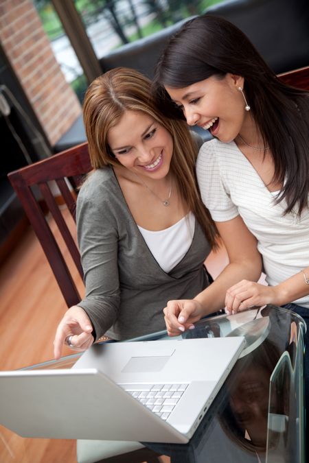 Women at home working on a laptop computer and looking surprised