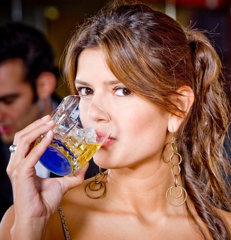 Portrait of a beautiful woman at a party having a drink