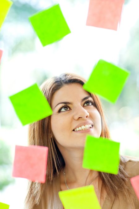 Multitask woman with post-its all around and smiling