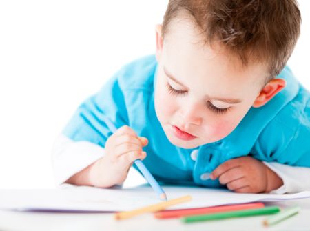 Happy boy coloring a book - isolated over a white background