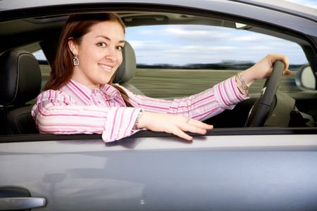 business woman smiling and driving a brand new car