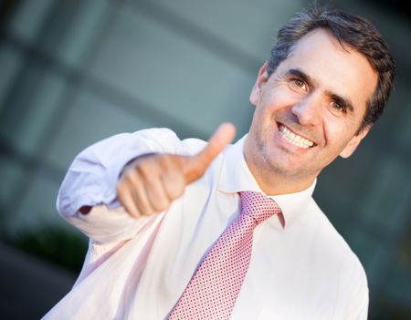 Positive businessman with thumbs up and smiling