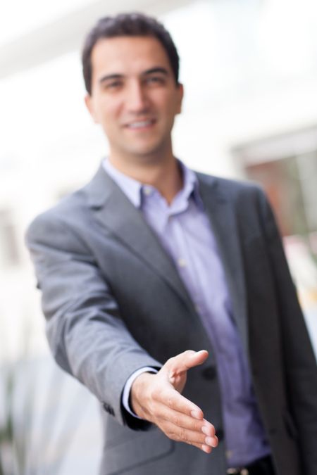 Business man with hand extended to handshake