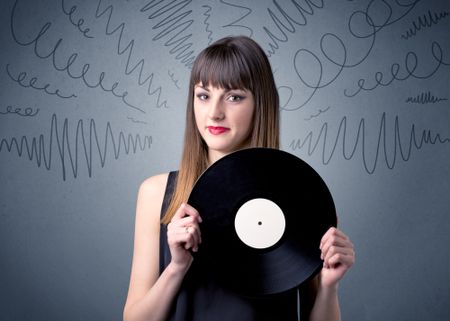 young-lady-holding-vinyl-record-grey-1039094785 Young lady holding vinyl record on a grey background with scribbles around her