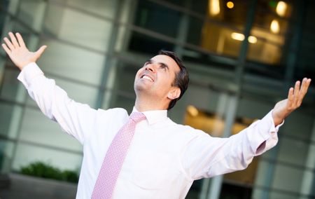 Successful businessman with arms open and smiling