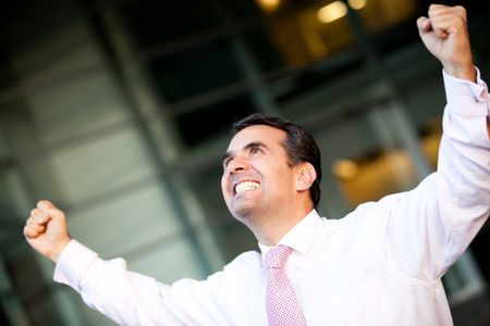 Businessman celebrating his success with arms up