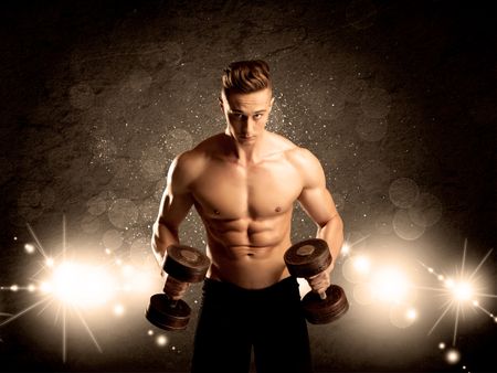 An attractive muscular guy working out with weights and showing naked upper body with illustrated lights and bokeh concept