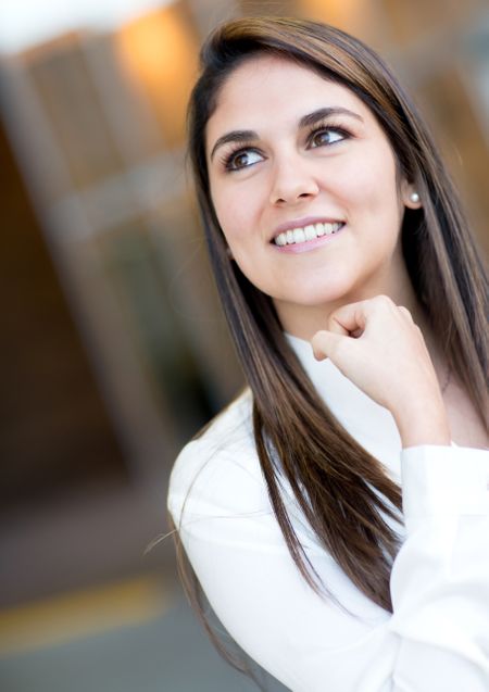 Portrait of a pensive businesswoman looking up and smiling